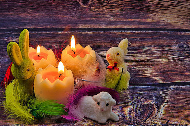浪漫的复活节构图，燃烧着蜡烛、兔子和复活节羔羊，彩色羽毛，复古风格