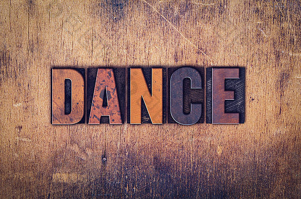 “舞蹈”这个词是用肮脏的复古活版印刷字体写在古老的木质<strong>背景</strong>上的。