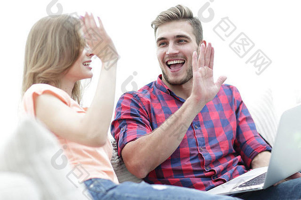 一对微笑的年轻夫妇拿着笔记本电脑的特写镜头