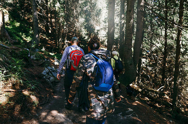 一群背着背包在茂密的森林里行走的游客。旅行和背包生活方式概念