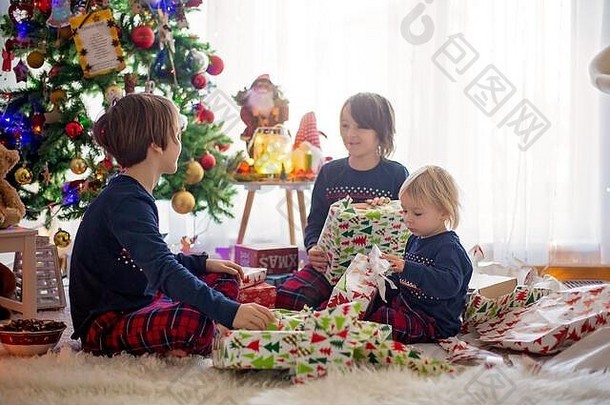 快乐的孩子们，孩子们，在圣诞节打开礼物，穿着睡衣