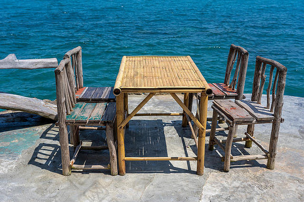 热带海滩海水旁空荡荡的咖啡馆里有竹桌子和木椅子。闭合。泰国高潘根岛