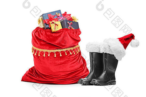 圣诞老人的配饰、一双靴子和一个装满礼物的袋子，这些都是在白色背景下隔离开来的