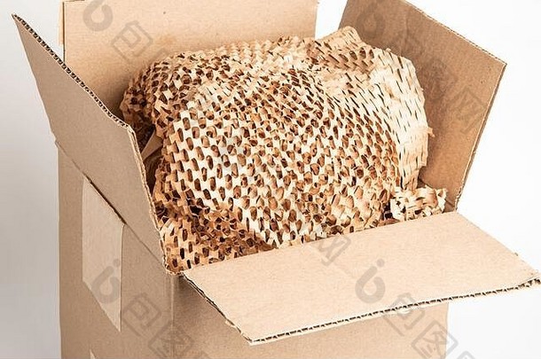一个封闭的通用棕色纸箱包装盒与棕色横切纸填充拍摄。