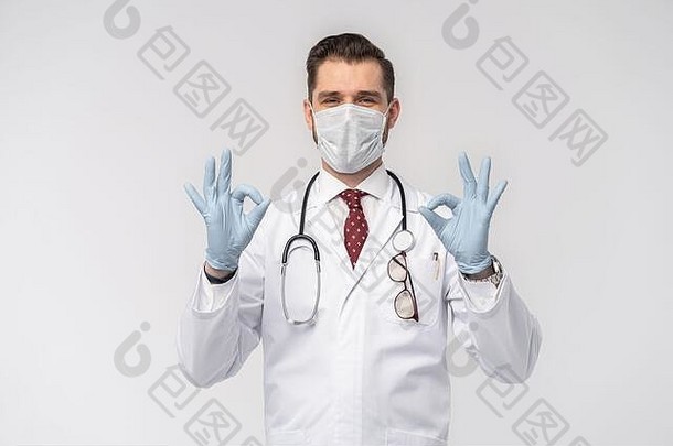 冠状病毒。新冠肺炎大流行漂亮帅气的医生戴着防护面罩，白色的实验室外套隔离在白色表面
