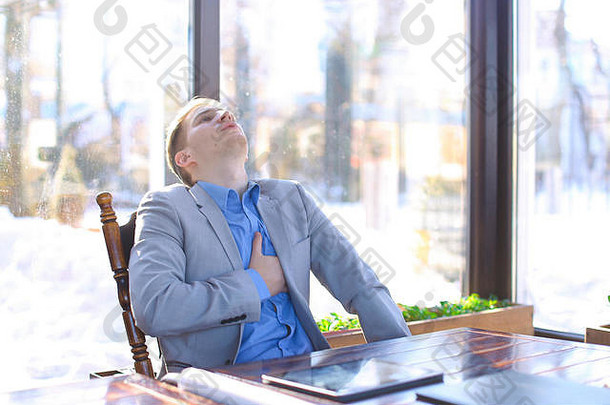 精疲力竭的男子在咖啡馆休息，在卷纸旁使用平板电脑