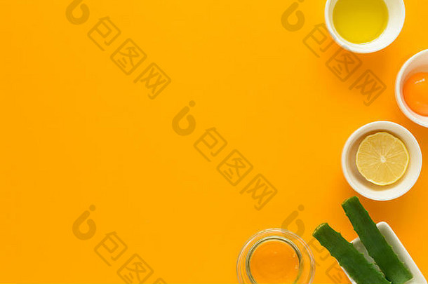 黄色背景的有效痤疮治疗的新鲜成分。蜂蜜、海盐、蛋黄、橄榄油、燕麦、柠檬和芦荟。平铺。复制