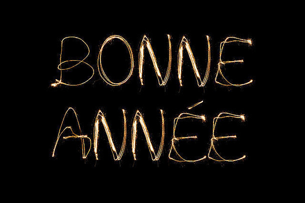 Bonne Annee（法国新年快乐）用黑色背景上孤立的火花笔书写