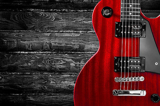 木制背景上红色电吉他的一部分。书写文本的地方