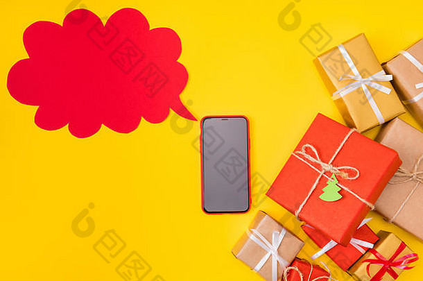 圣诞季节折扣概念。上图：手机的高角度照片告诉x-mas销售新颖的语音卡片许多泡泡礼品盒摆在那里