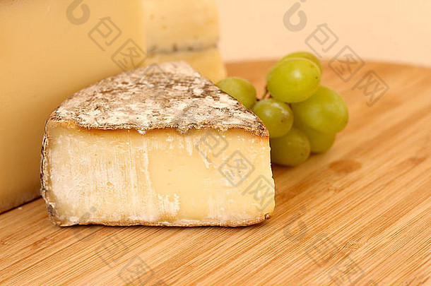 木板上的奶酪和绿葡萄