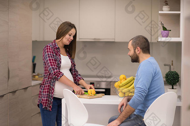 年轻的怀孕了夫妇烹饪食物水果柠檬汁厨房生活方式健康的怀孕快乐生活概念