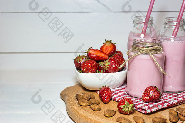 新鲜<strong>草莓</strong>、杏仁和水果酸奶放在木盘上。健康营养概念。