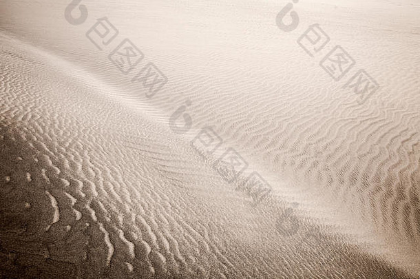 沙丘表面的沙和风模式。图案由两种类型的沙粒组成-深色、小而轻和大而轻和重