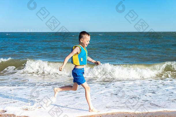 一个患有多动症、孤独症、阿斯伯格综合症的英俊男孩在美丽的夏日在海边游泳，在海里泼水，精力充沛，