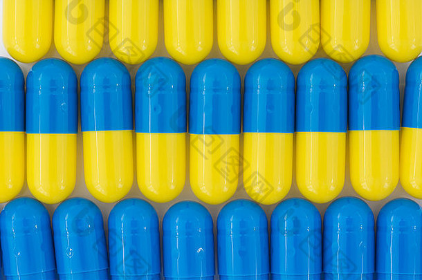 药丸特写-胶囊形式制成的明胶。蓝色/黄色药片。比喻在高药价问题上与美国制药公司较量。