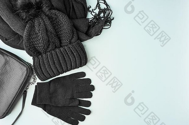 平铺冬季或秋季保暖女士配饰-黑色针织围巾、帽子、亮蓝色背景上的包、空间