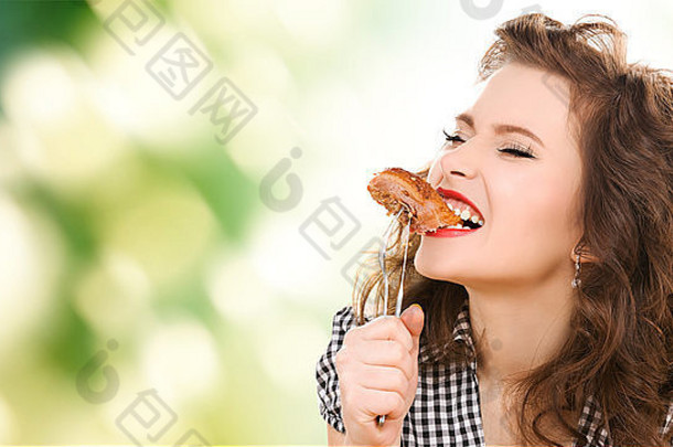 饿了年轻的女人吃肉叉绿色