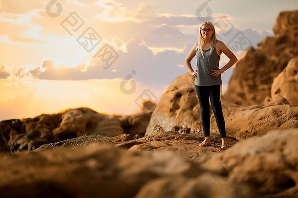 旅行概念回来年轻的健身女孩站岩石山景观