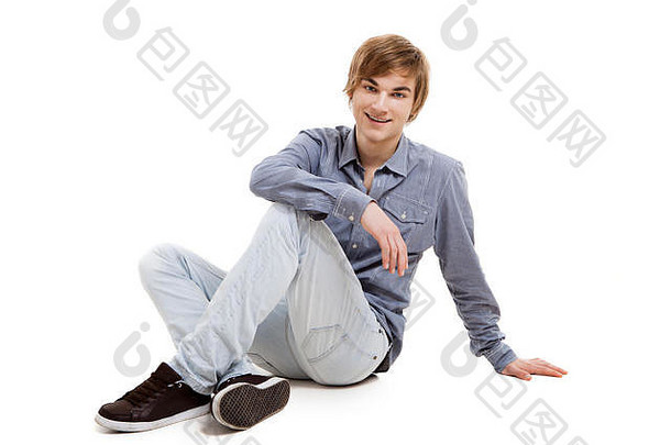 快乐的年轻人坐在地板上，背景是白色的