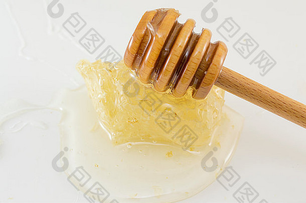 蜂巢，白色<strong>背景</strong>上有蜂蜜和勺