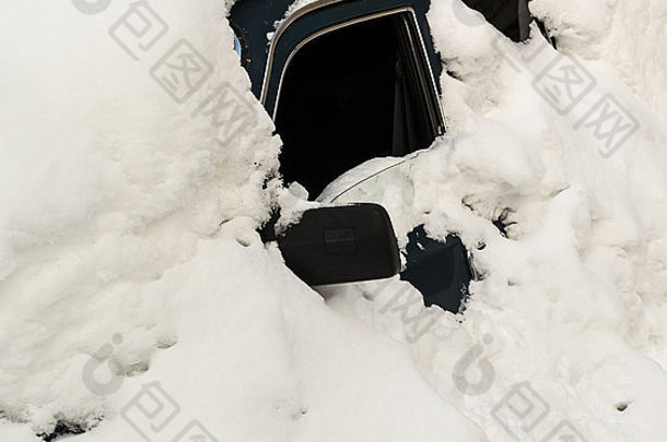 废弃的车窗敞开的雪盖汽车被一团白雪完全遮住了。这辆车被遗弃了，业主立案法团
