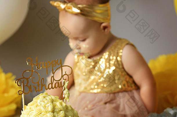 一岁小女孩把她的黄色蛋糕弄碎了
