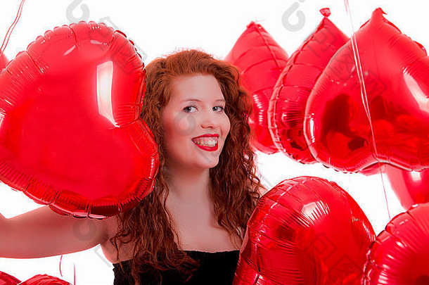 一个快乐的小女孩在红气球之间的特写镜头。