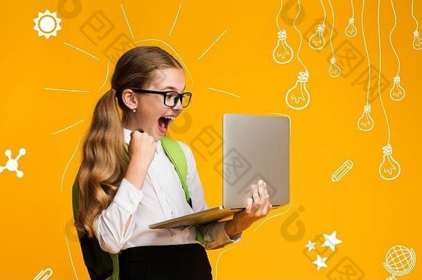 儿童的现代教育。欣喜若狂的女学生背着背包，拿着笔记本电脑，对考试成绩感到高兴