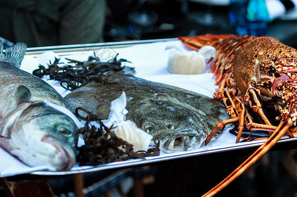 在盘子上放上新鲜的多拉德、鲽鱼和龙虾