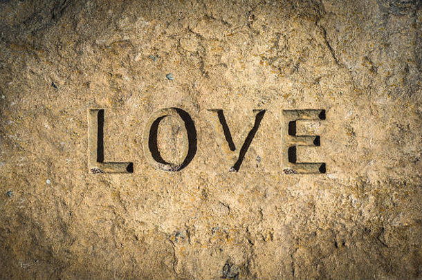 刻在石头或岩石上的“爱”一词的概念形象