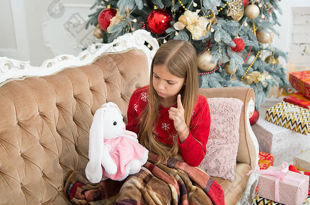 你应该听我说。小女孩在圣诞树上教可爱的兔子。小孩把手指指向柔软的<strong>玩具</strong>。小女孩抱着兔子<strong>玩具</strong>。带礼物的小孩。最好的圣诞<strong>玩具</strong>。