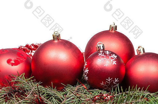 绿色云杉枝上的红色圣诞球在白色背景上隔离