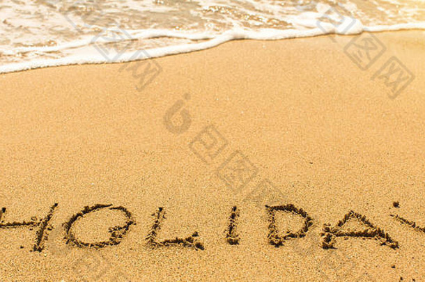 假日-手写在沙滩上的海浪线。