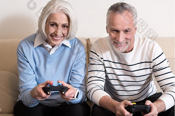 高兴的老夫妇在家玩游戏机