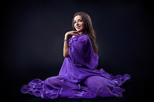 美年轻的女孩跳舞紫色的面纱阿拉伯语风格服装黑暗