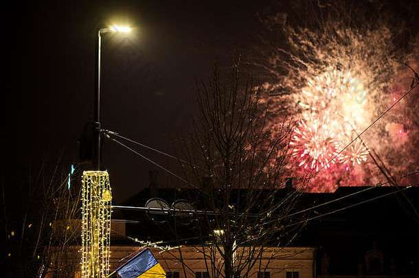 五颜六色，美丽的烟花在城市上空的夜空中绽放。新年庆典。模糊的流星。