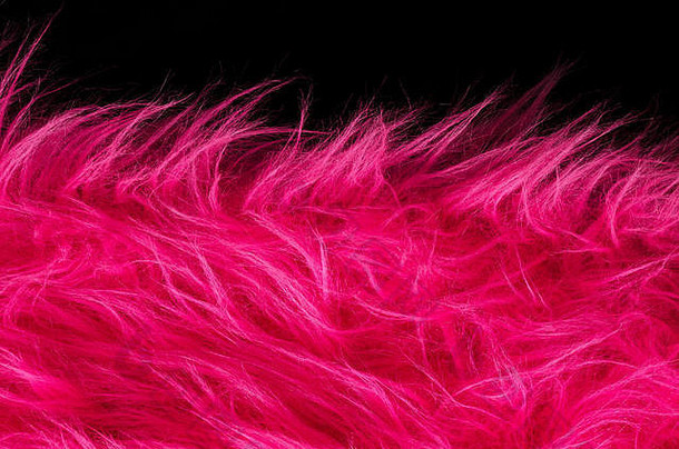 粉色毛绒面料，黑色背景，水平。由长毛合成纤维制成的非常柔软的聚酯织物。宏。