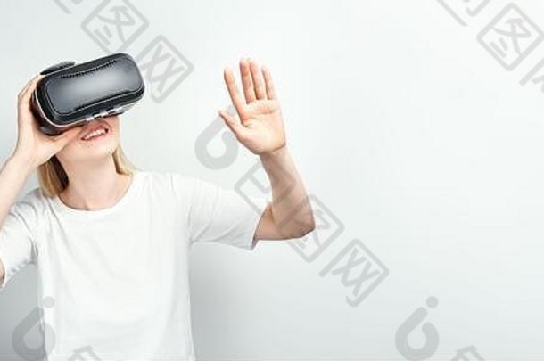 快乐微笑的年轻漂亮女孩l在家里使用虚拟现实的虚拟现实耳机眼镜有很多手势
