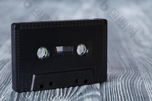灰色木质背景上的黑色录音带。复古风格。软焦点。
