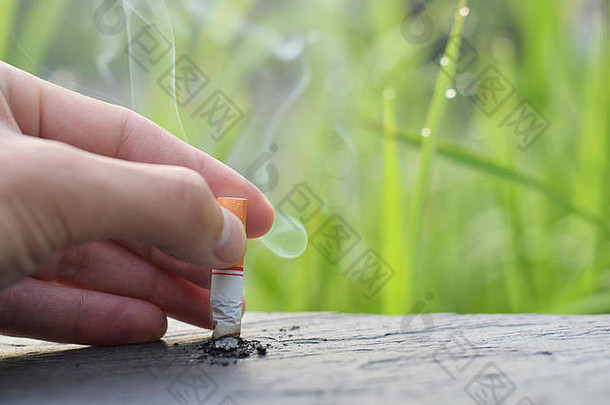 停止吸烟停止吸烟的概念，手放下香烟下来到木桌上停止吸烟。