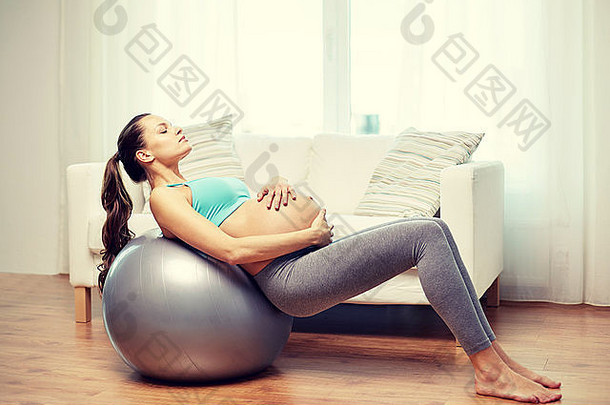 快乐的孕妇在家里健身
