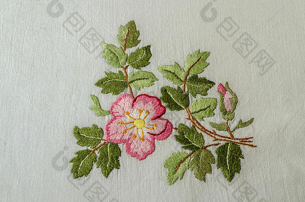 亚美尼亚埃里温，2018年6月4日：粉色花朵，带花蕾和叶子的茶玫瑰，在粗糙的棉布上绣有缎纹