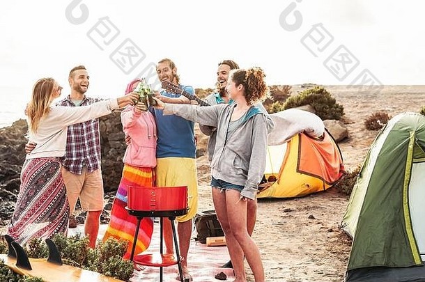 快乐的朋友们在烧烤野营派对上举杯畅饮啤酒——一群时髦的年轻人在露营地一起吃喝玩乐