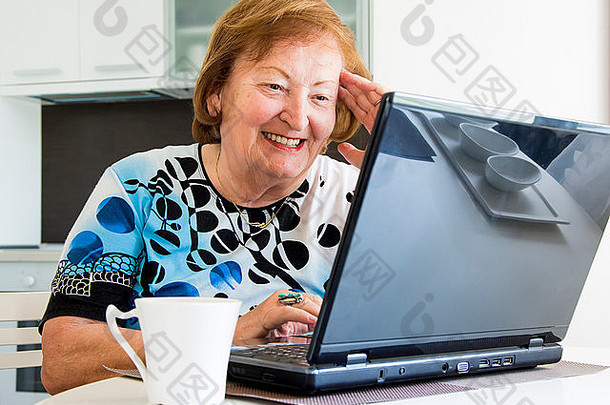 老妇人在电脑前上网搜索