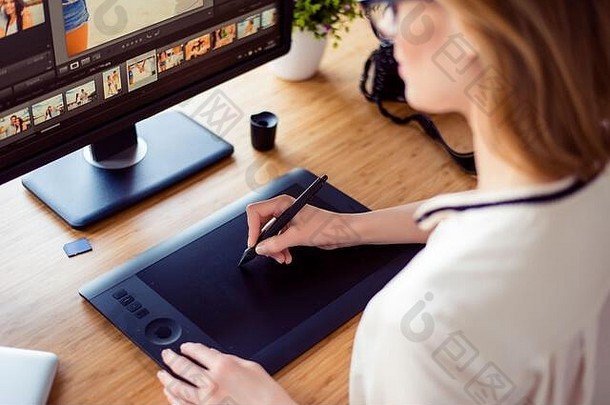 图形设计师在工作站的计算机上使用交互式笔显示、数字绘图板和笔的后视图