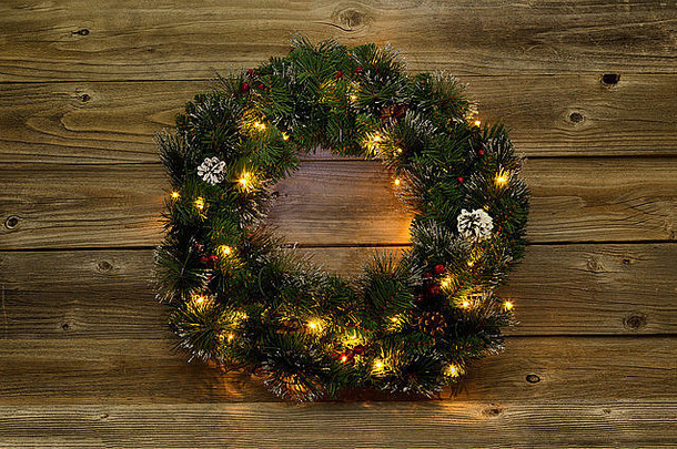 乡村木板上有白光的圣诞花环。低照度，使灯光发光。