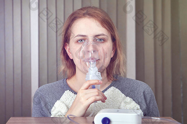 这位年轻女子正在做用于治疗呼吸系统疾病的吸入式雾化器，她使用压缩机雾化器系统。