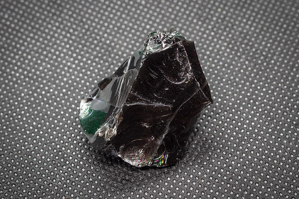 地质标本自然黑色的分层矿物黑曜石又名火山玻璃龙玻璃准宝石的石头黑色的背景