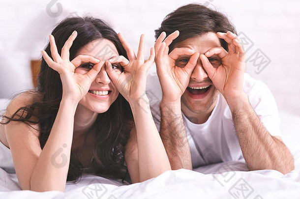 快乐的夫妇持有手指眼睛眼镜